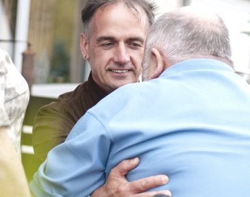 Mann bekommt Hilfe beim aufstehen 