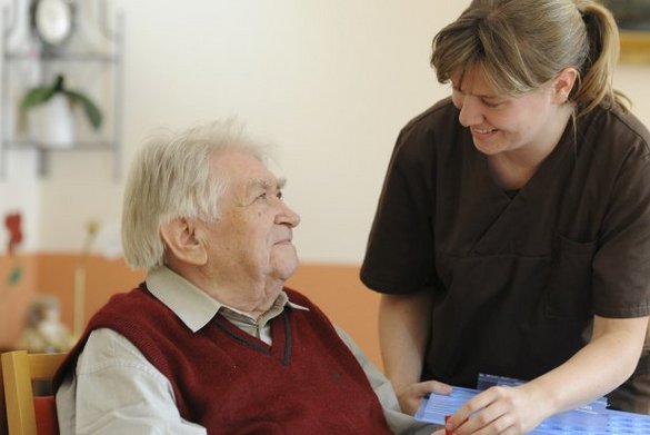 Pflegekraft und Bewohner bei der Gabe von Medikamenten