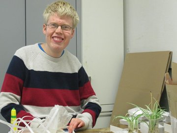 Junger Mann Prader-Willi-Syndrom am Arbeitsplatz