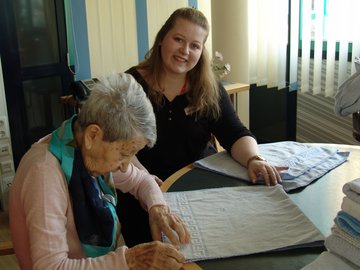Zwei Frauen legen Handtücher zusammen