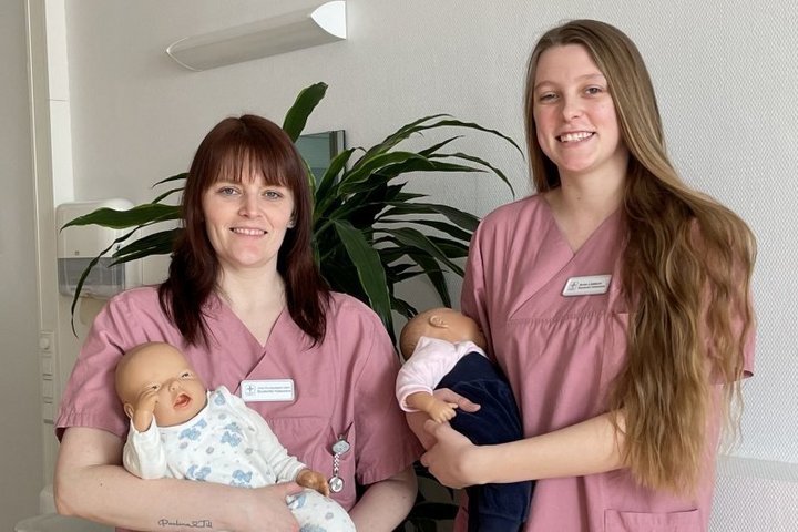 Zwei Hebammenstudentinnen der Hunsrück Klinik halten Babypuppen im Arm