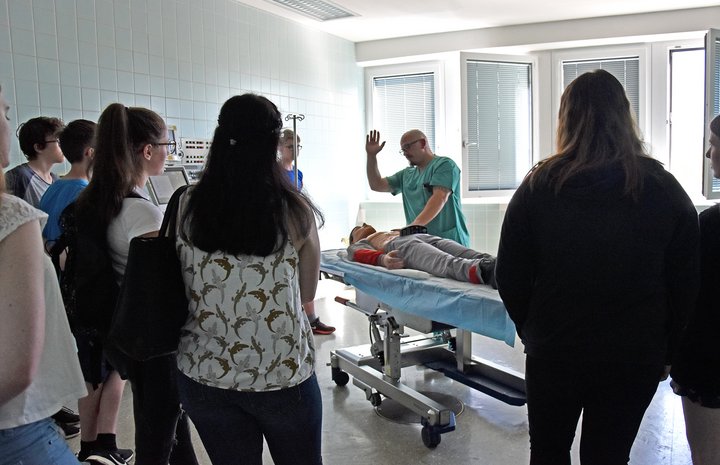 Menschen stehen am Bett und schauen zu