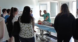 Menschen stehen am Bett und schauen zu