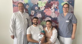 4 Personen und 1 Baby lächeln in die Kamera