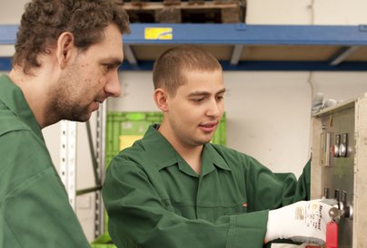 Beschäftigte arbeiten an einer Maschine