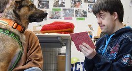 Ein junger Mann in Interaktion mit einem Hund im Rahmen der tiergestützten Therapie auf der Asbacher Hütte der Stiftung kreuznacher diakonie