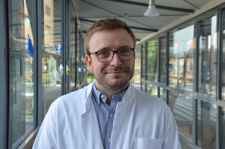 Arzt im weißem Kittel lächelt in die Kamera