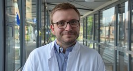 Arzt im weißem Kittel lächelt in die Kamera