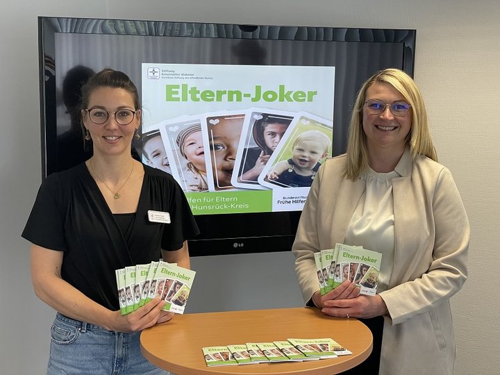 Annika Frank und Kristina Theodoropoulos zeigen die kostenlose Elternbroschüre Elternjoker