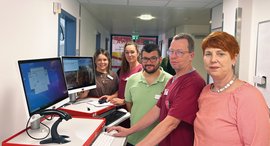 Mitarbeitende aus IT und Pflege überprüfen am PC die Inhalte der digitalen Patientenakte