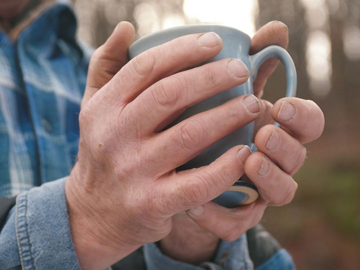 Hände halten Teetasse