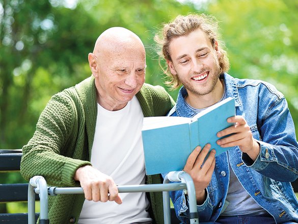 Junger Mann liest älterem Mann vor