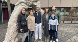 Personen stehen vor einem Krankenhaus und lächeln