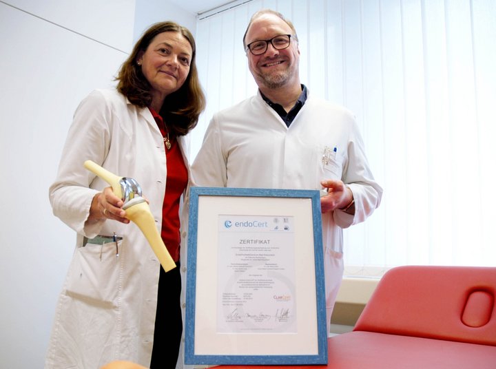 ßrztin und Arzt mit Urkunde