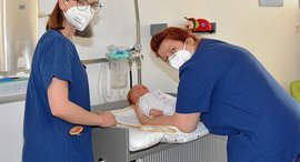 Hebammenschülerinnen versorgen Säugling im Diakonie Krankenhaus