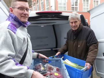 zwei Männer, die Tafel-Kisten packen