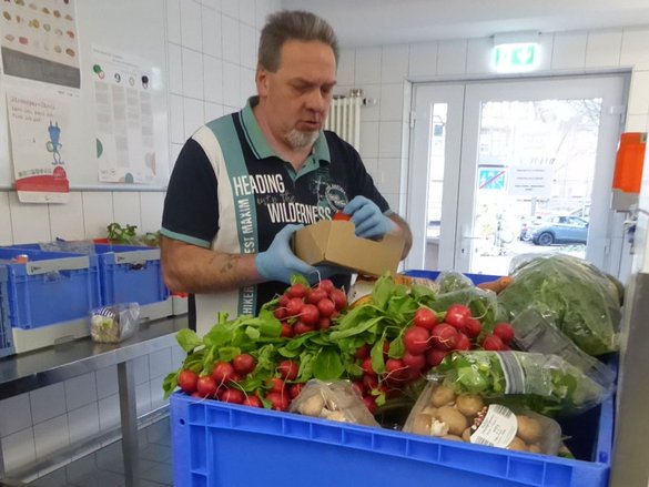 Mann, der Tafelkiste mit Gemüse packt