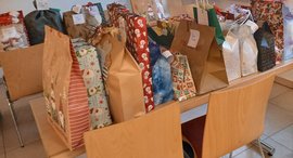 Tüten, die mit kleinen Geschenken für Kinder befüllt sind, stehen auf einem Tisch