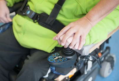 Unterstützung für einen Mann bei der Steuerung des Rollstuhls