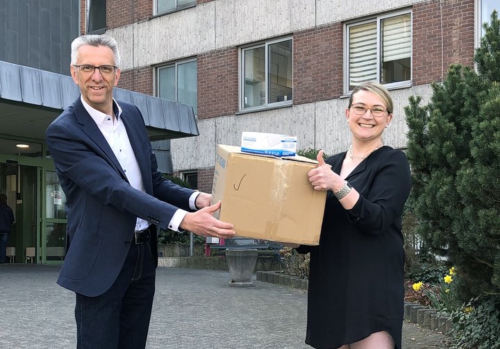 Erik Gregori überreicht die Masken an Kristina Theodoropoulos