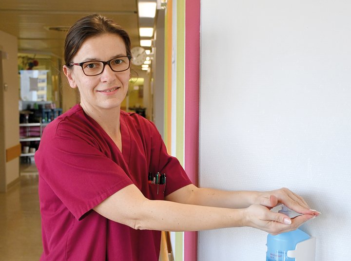 Frau desinfiziert sich im Krankenhaus die Hände