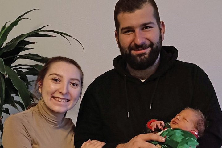 Mutter und Vater halten neugeborenes Baby im Arm