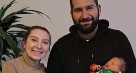 Mutter und Vater halten neugeborenes Baby im Arm