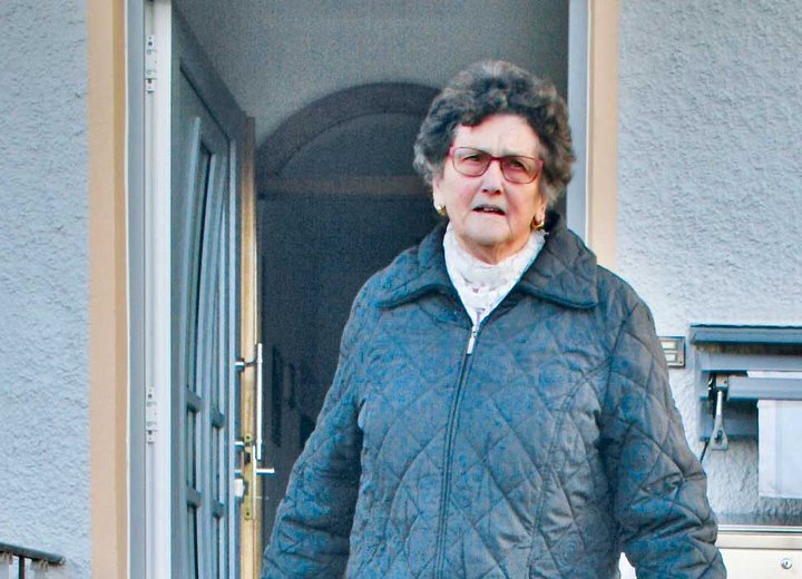 ßltere Frau vor Haustür