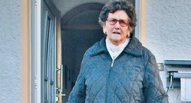 ßltere Frau vor Haustür