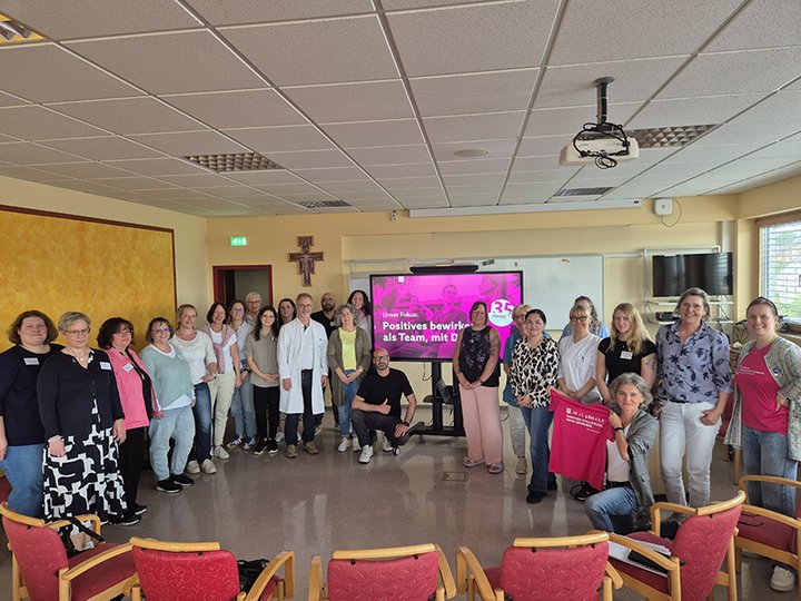 Mitarbeitende der Klinik stehen im Kreis für ein Gruppenfoto