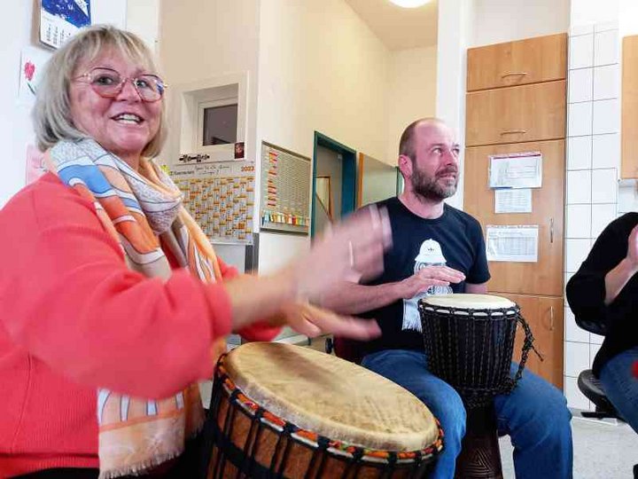 Frau trommelt auf Djembe in der Tagesförderstätte der Stiftung kreuznacher diakonie