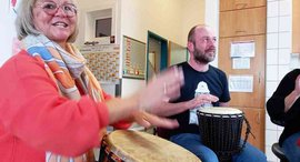 Frau trommelt auf Djembe in der Tagesförderstätte der Stiftung kreuznacher diakonie