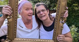 Zwei Frauen schauen durch einen Bilderrahmen