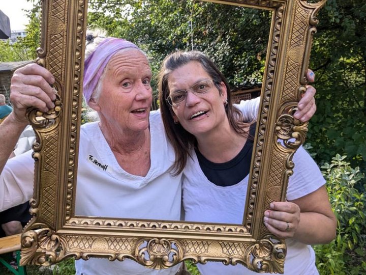 Zwei Frauen schauen durch einen Bilderrahmen