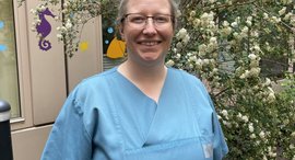 Frau in OP-Kleidung lächelt in die Kamera