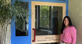 Frau steht vor Schuleingang