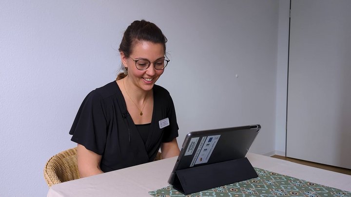 Frau sitzt vor Tablet und chattet mit Familie