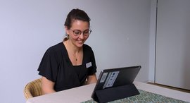 Frau sitzt vor Tablet und chattet mit Familie