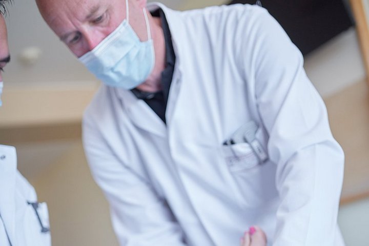 Mann untersucht einen verbundenen Fuß