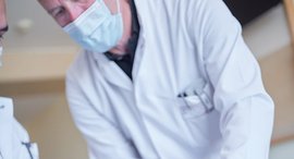 Mann untersucht einen verbundenen Fuß