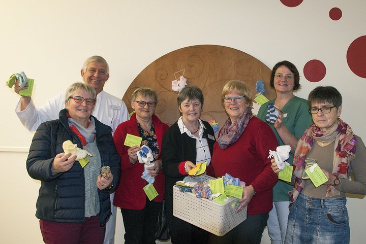 Personen mit Babysocken in der Hand