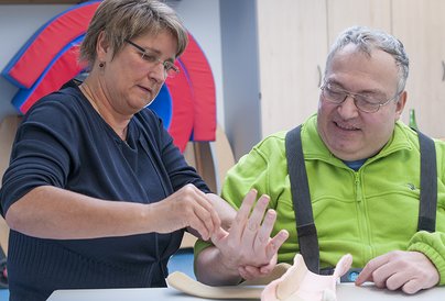 Frau und Mann: Anpassen einer Arm-Orthese