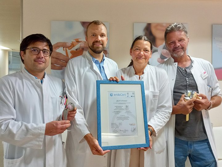 drei Männer und eine Frau in weißen Hemden 