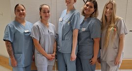 Gruppfenfoto von fünf angehenden Pflegefachpersonen auf der Kinderstation der Diakonie Kliniken