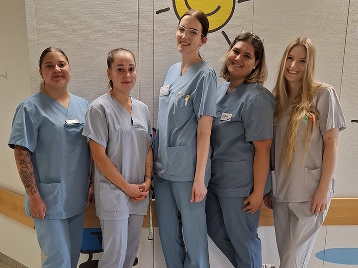 Gruppfenfoto von fünf angehenden Pflegefachpersonen auf der Kinderstation der Diakonie Kliniken