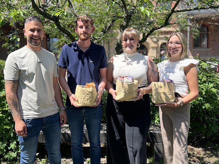 Ausbilder Marc Heimann gratuliert einem Mann und zwei Frauen zum Abschluss ihrer Ausbildung Büromanagement